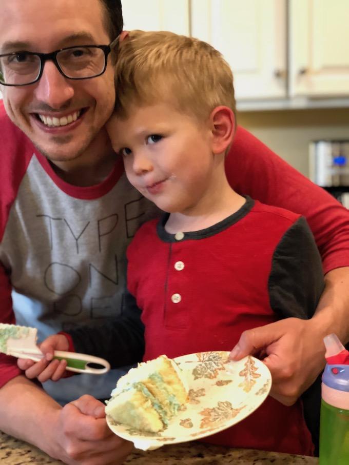 dad and son eating gender reveal cake